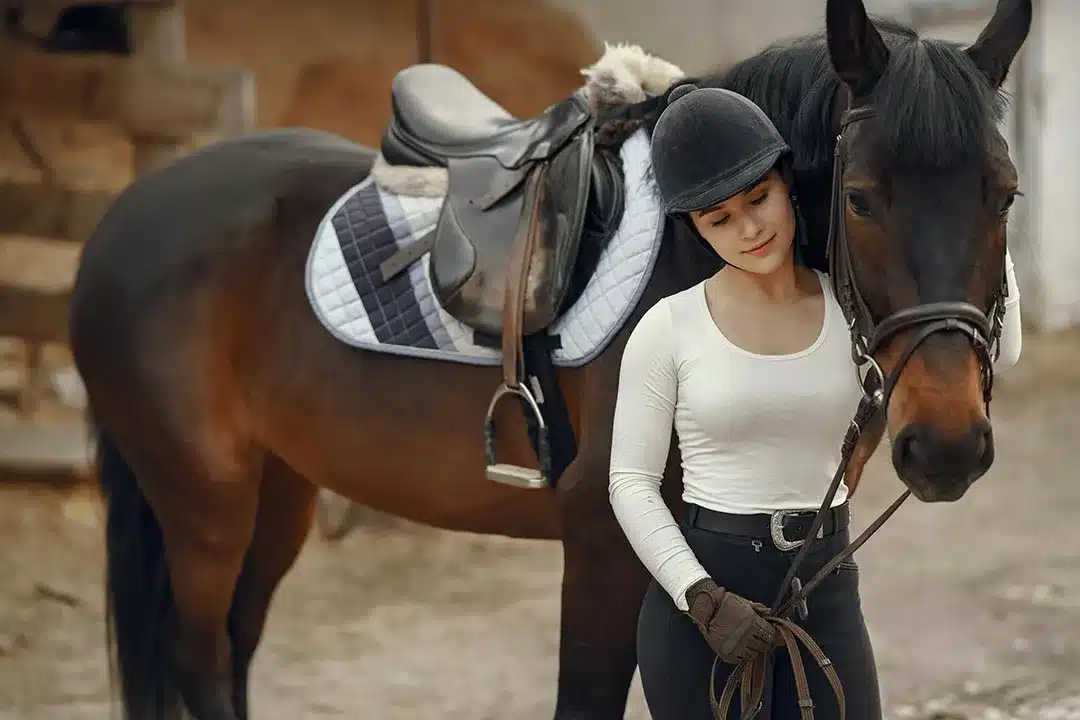 Kvinde træner horsemanship med hest i ridehal